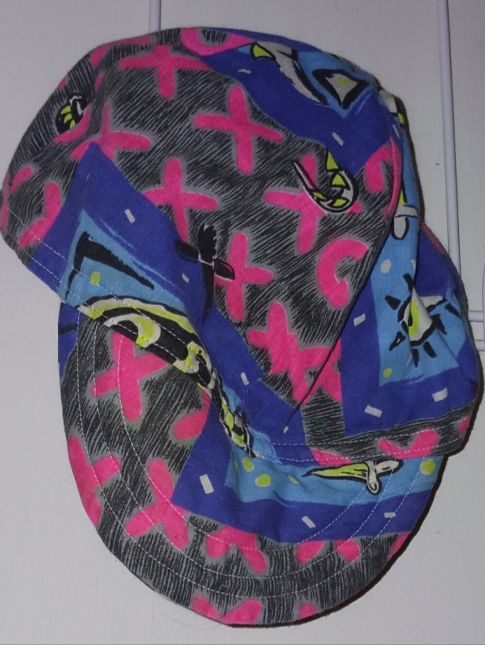 Multi-colored bucket hat with pink, blue, and black abstract graphic design